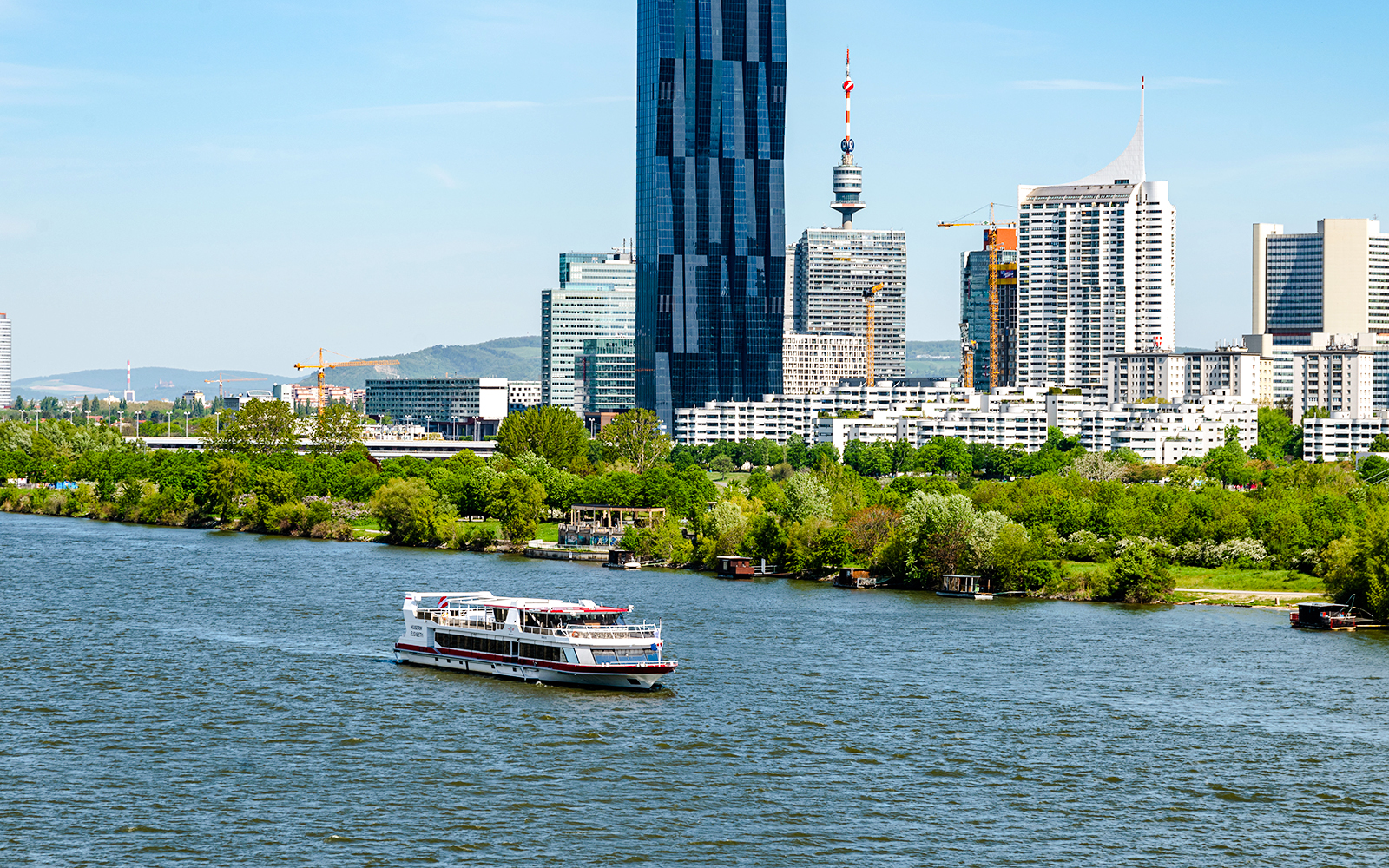 MS Vienna boat cruising on the Danube River with Vienna skyline, Austria.