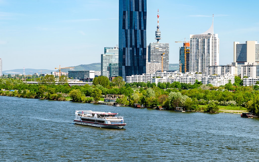 MS Vienna boat cruising on the Danube River with Vienna skyline, Austria.