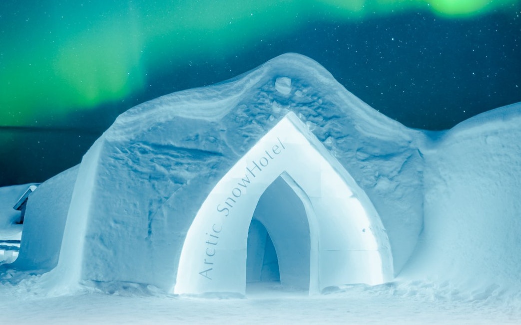 Exterior of Arctic SnowHotel under northern lights.