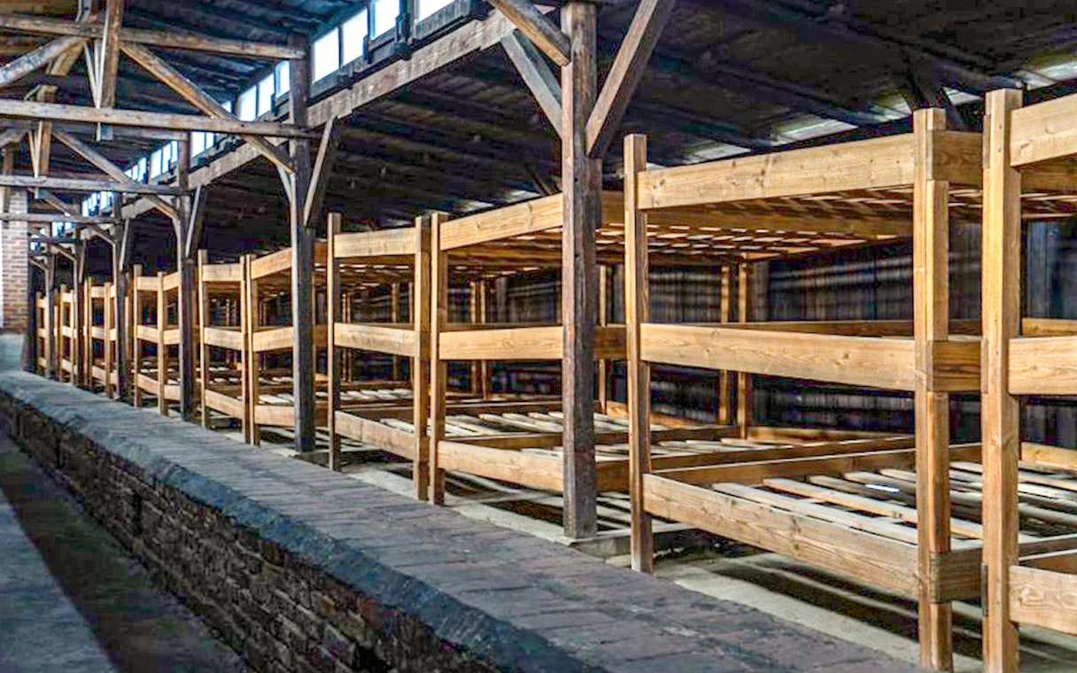 Wooden barracks interior at Auschwitz-Birkenau, part of the guided tour experience.