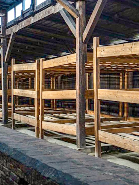Wooden barracks interior at Auschwitz-Birkenau, part of the guided tour experience.