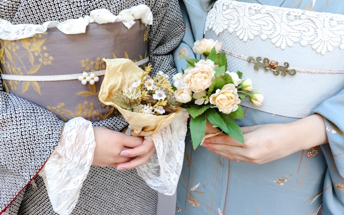 Couple in kimonos holding floral bouquets, Japan.