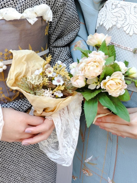 Couple in kimonos holding floral bouquets, Japan.