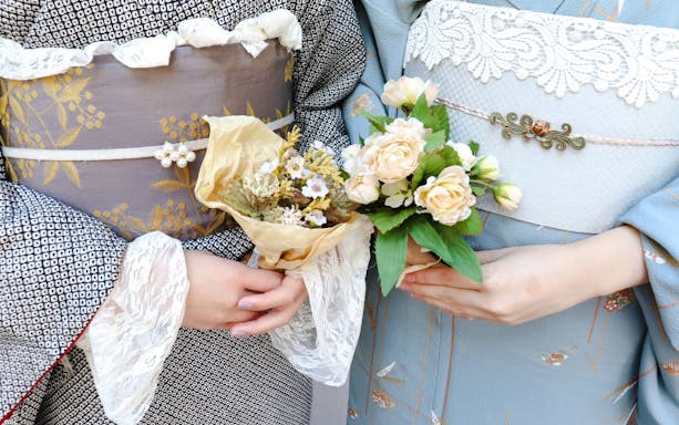 Couple in kimonos holding floral bouquets, Japan.