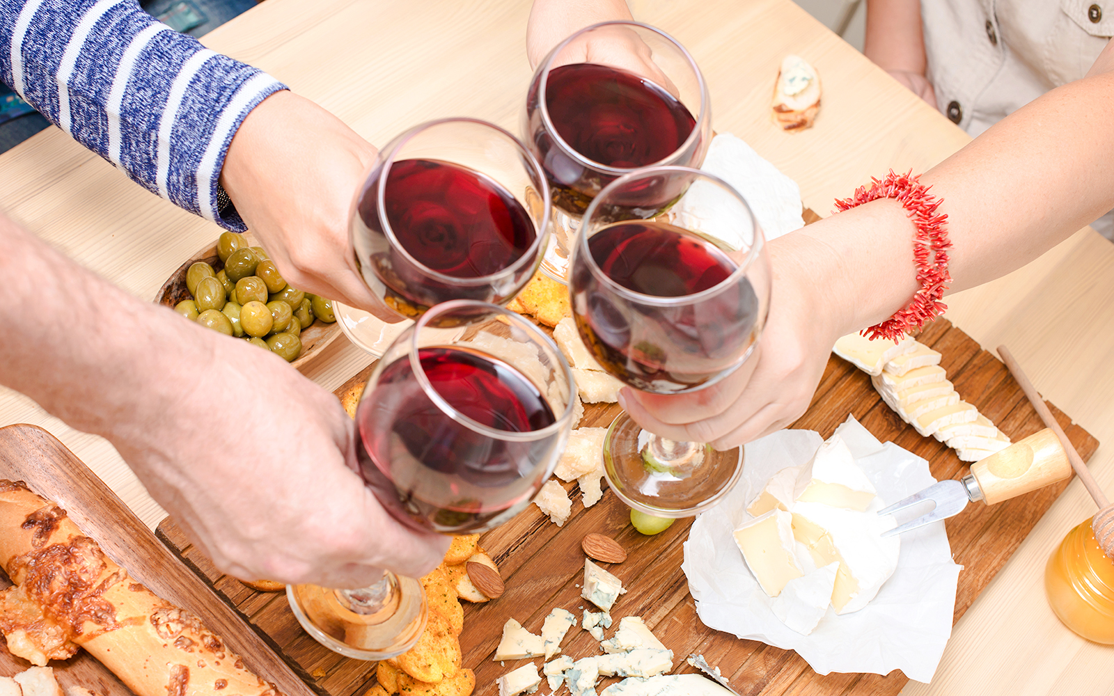 Clinking wine glasses over cheese platter at Cheese Museum, Paris.