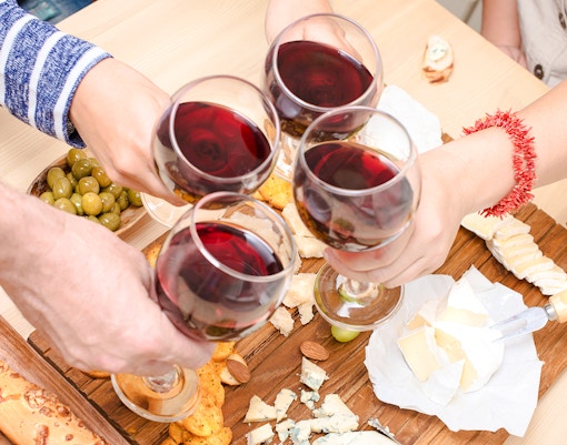 Clinking wine glasses over cheese platter at Cheese Museum, Paris.