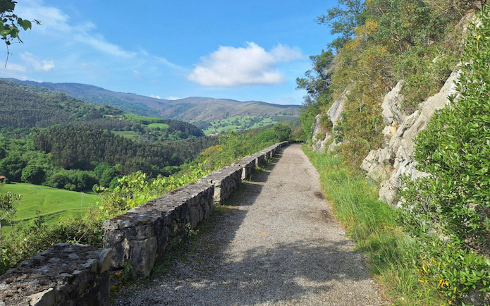 Pathway leading to Monte Castillo Caves with scenic mountain views in Cantabria, Spain.