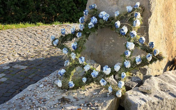 Wreath of blue and white flowers at Treblinka Extermination Camp memorial site.