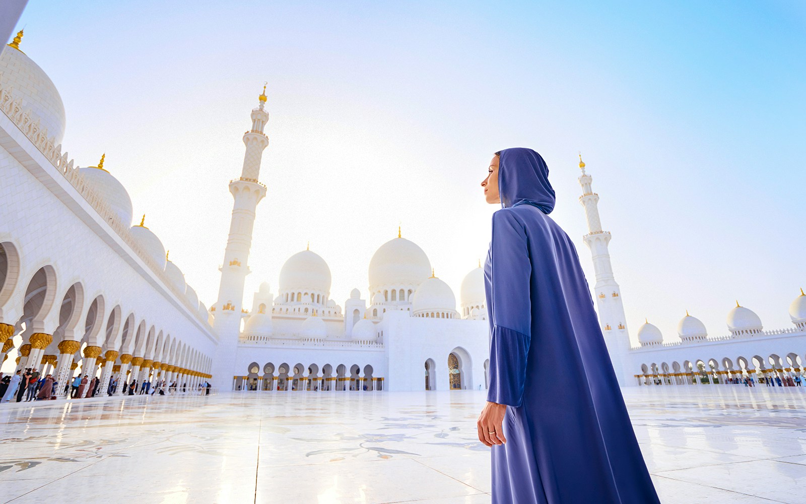 Woman in traditional abaya standing in the Sheikh Zayed Grand Mosque