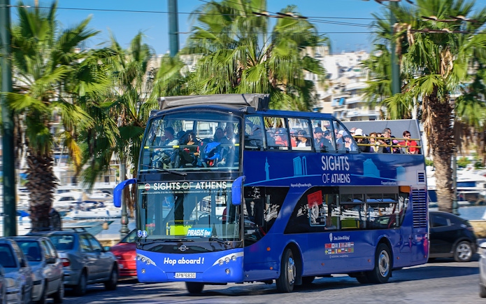 Open-top bus touring Athens with views of the Acropolis, Piraeus, and nearby beaches.