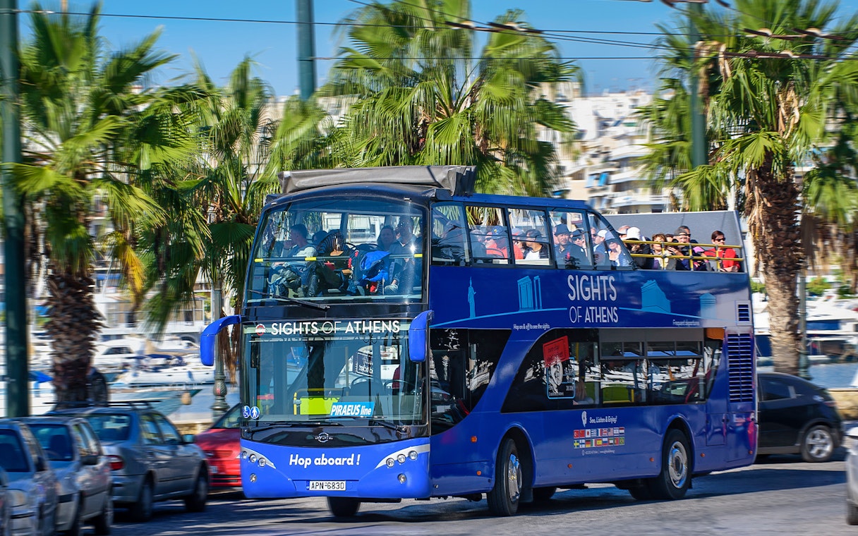 Open-top bus touring Athens with views of the Acropolis, Piraeus, and nearby beaches.