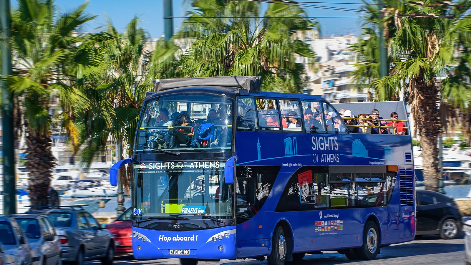 Open-top bus touring Athens landmarks, including the Acropolis, with views of Piraeus and nearby beaches.