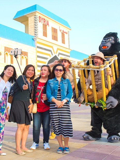 Visitors taking a selfie at Dubai Global Village with performers in costume.
