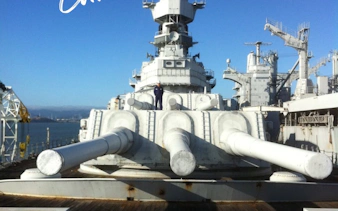 Battleship deck with large naval guns, part of Escape the Fleet Adventure tour.