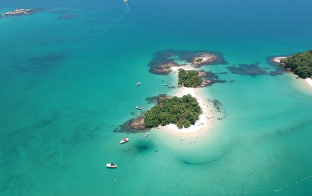 Aerial view of Ilha de Cataguás with turquoise waters and small boats.