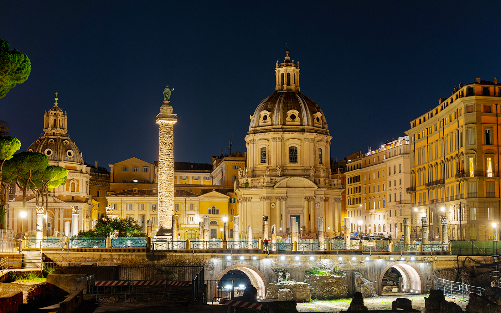 Fori Imperiali illuminated at night during Rome open bus tour with Eataly Roma tasting spot.