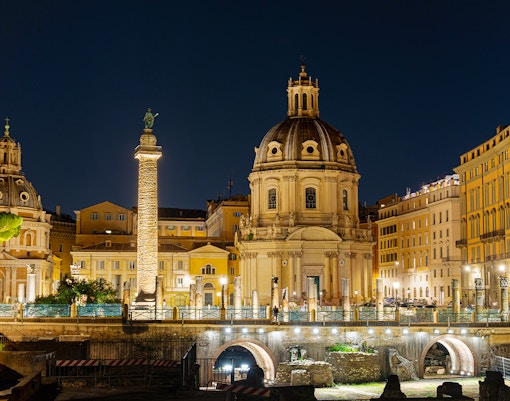 Fori Imperiali illuminated at night during Rome open bus tour with Eataly Roma tasting spot.