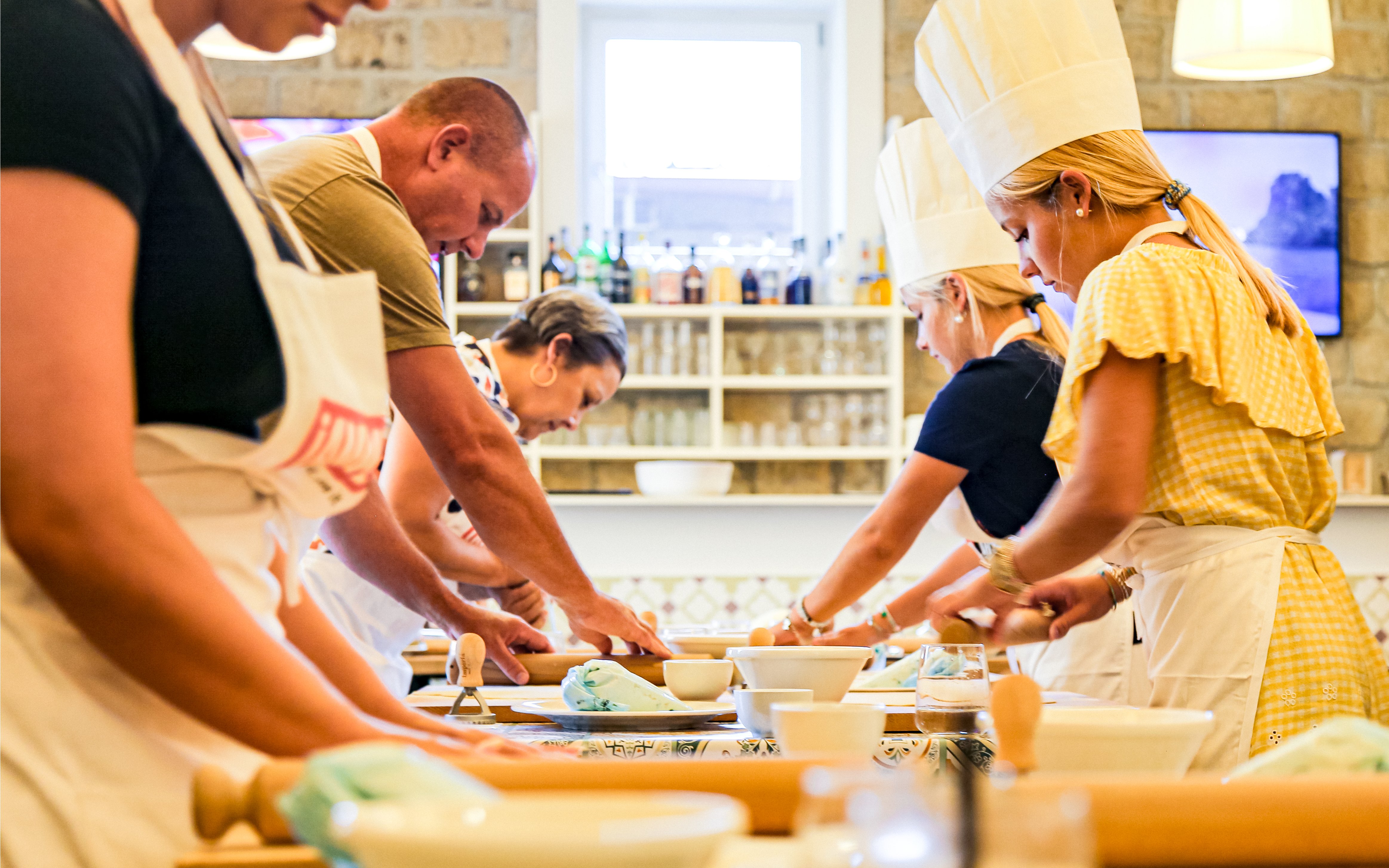 Tourists cooking at Neapolitan Cooking School in Sorrento.
