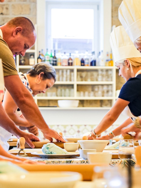 Tourists cooking at Neapolitan Cooking School in Sorrento.