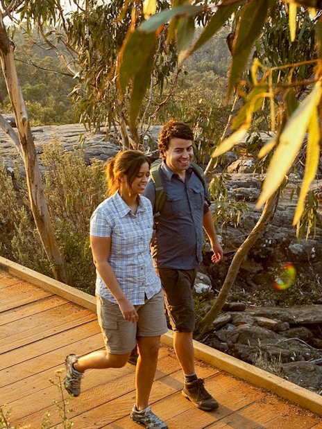 Couple walking on a wooden path in Grampians National Park during a guided eco tour from Melbourne.