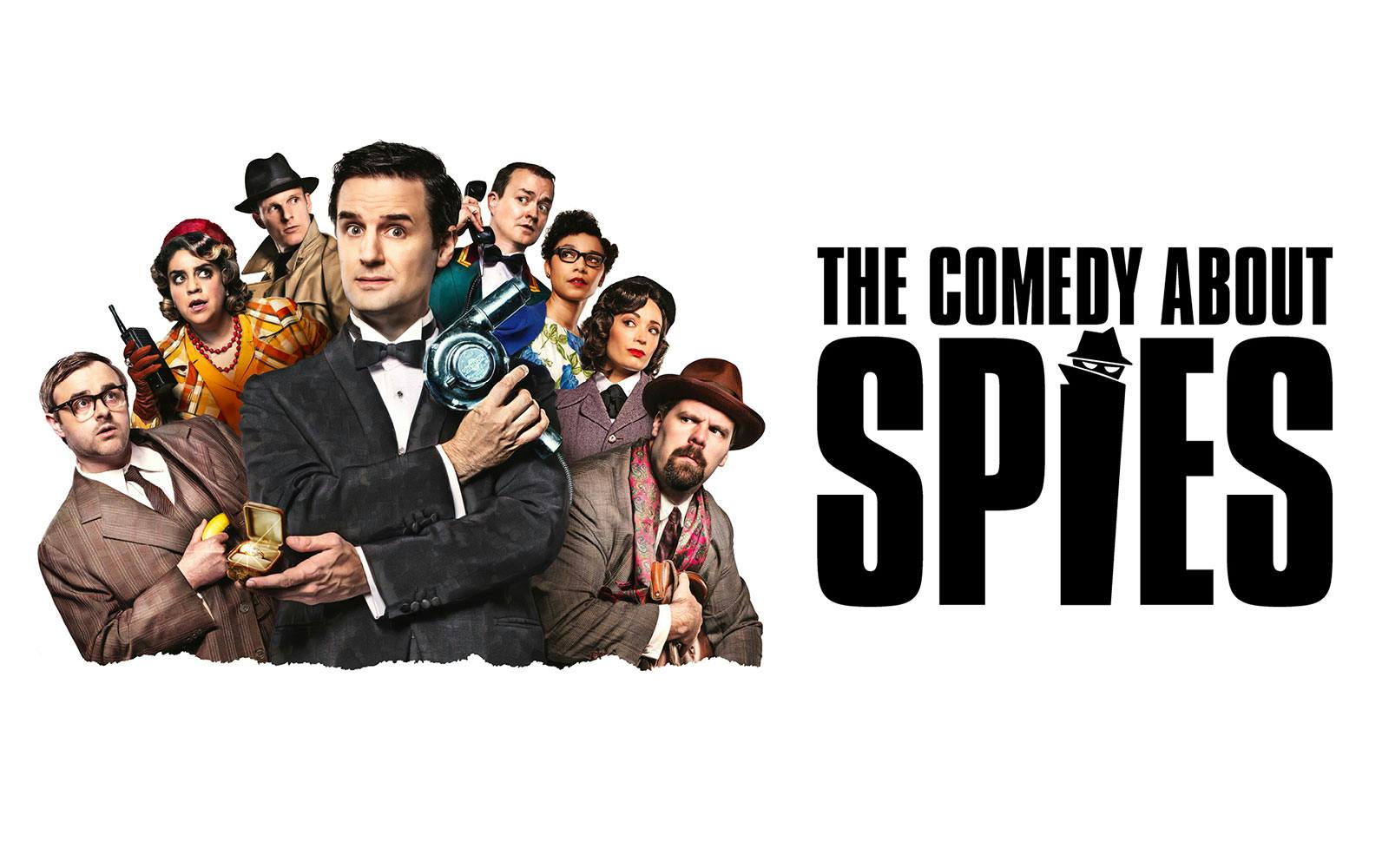 Cast of "The Comedy About Spies" in West End with spy gadgets and costumes.