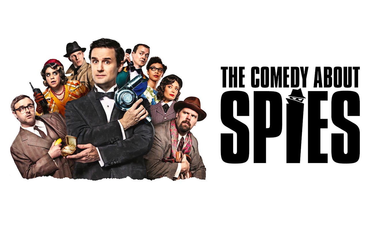 Cast of "The Comedy About Spies" in West End with spy gadgets and costumes.