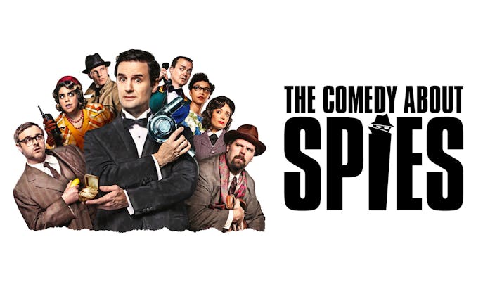 Cast of "The Comedy About Spies" in West End with spy gadgets and costumes.