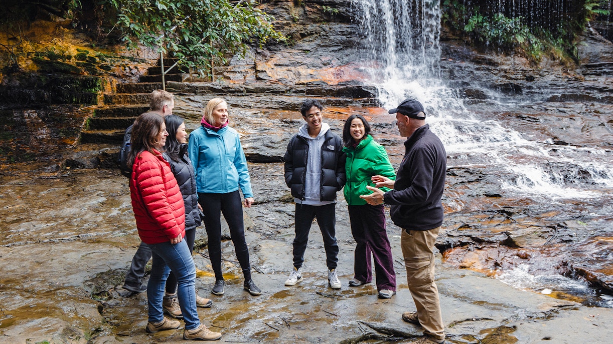 Guide leading group near waterfalls in Blue Mountains, Australia.