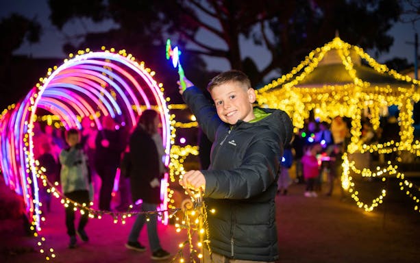 Child enjoying colorful lights at Sovereign Hill's Winter Wonderlights event.