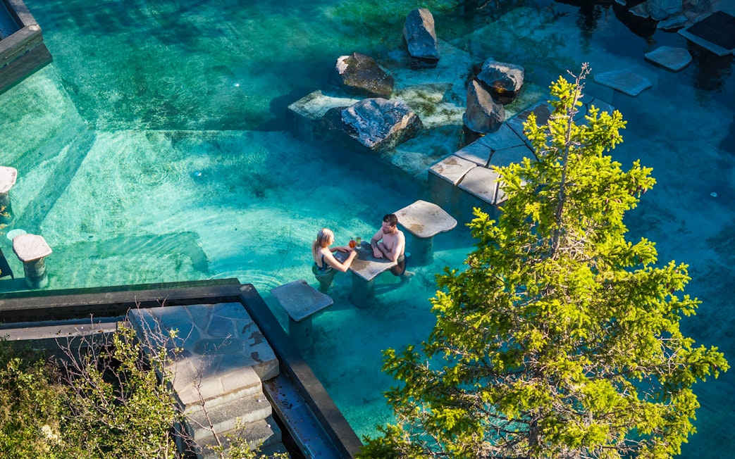 Couple relaxing in Forest Lagoon geothermal spa, Vaðlaskógur forest, near Akureyri, North Iceland.