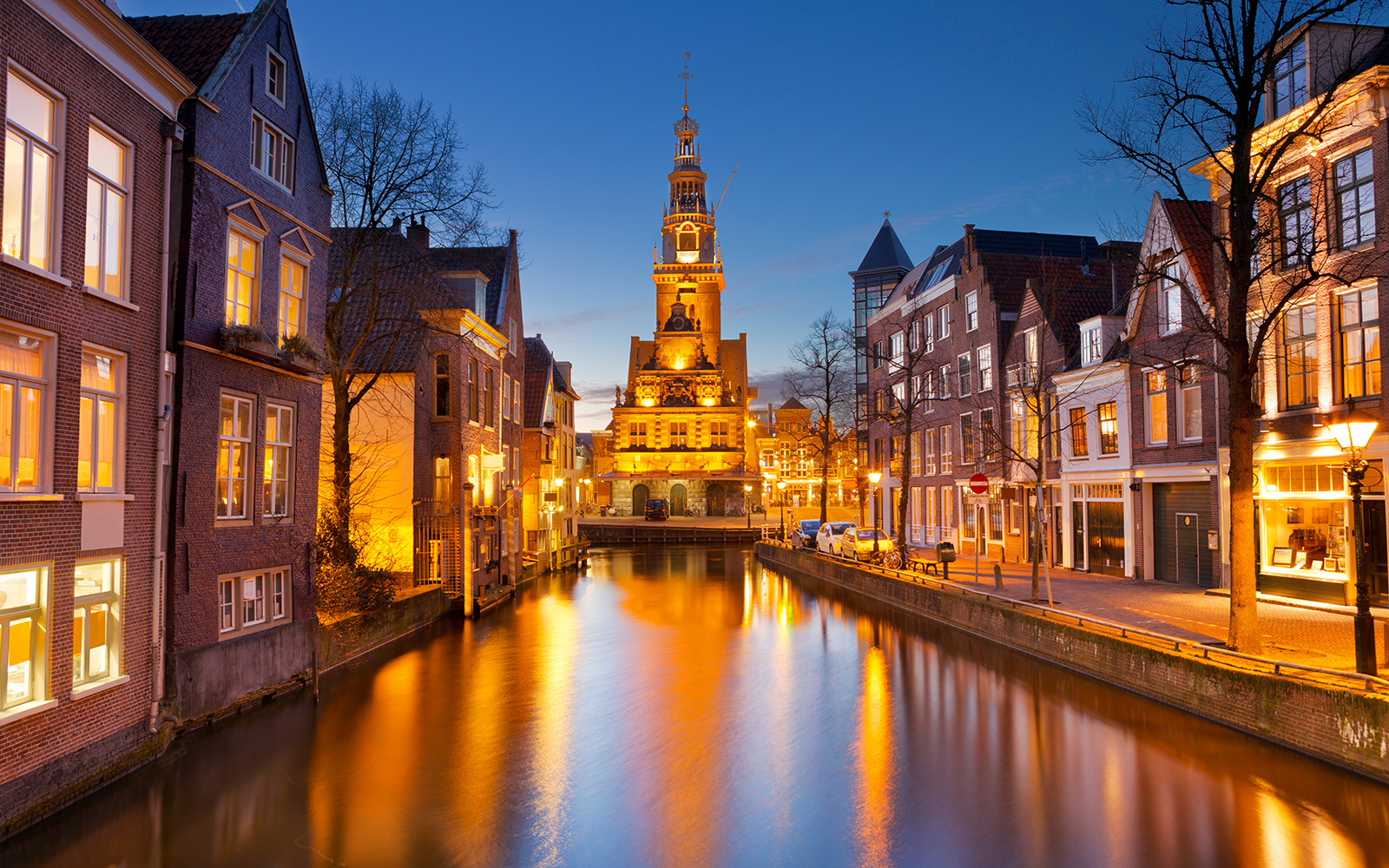 Alkmaar cityscape at night with illuminated historic buildings and canal in The Netherlands.