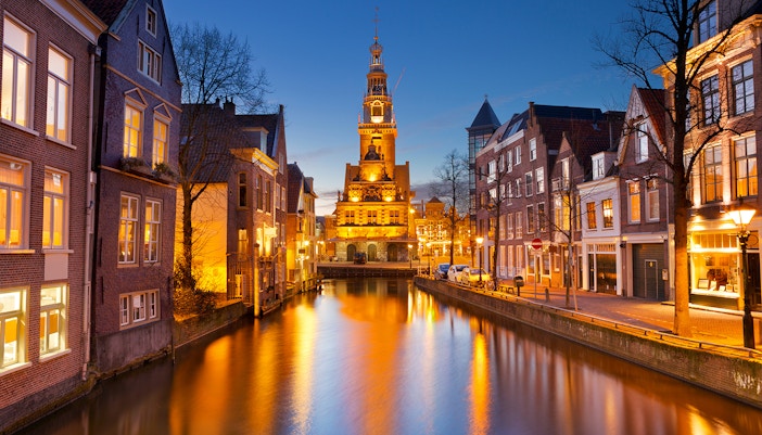 Alkmaar cityscape at night with illuminated historic buildings and canal in The Netherlands.