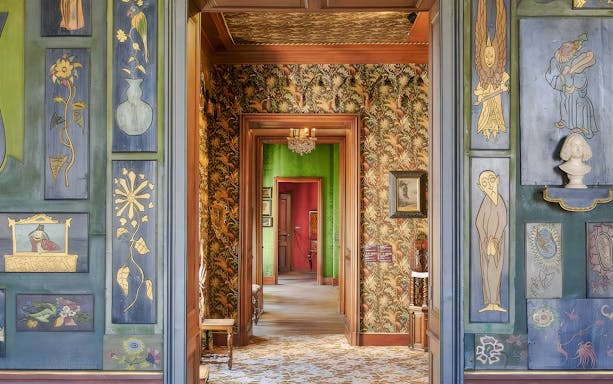 Interior hallway of The Victor Hugo House in Paris, featuring ornate wall art and vibrant decor.