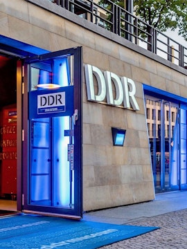 DDR Museum entrance in Berlin with illuminated blue doorway.