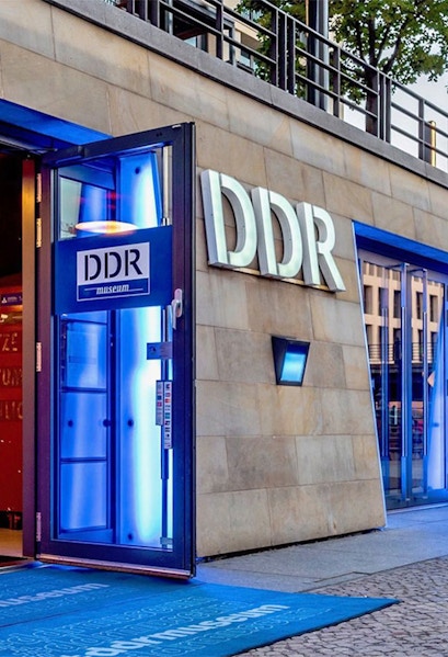 DDR Museum entrance in Berlin with illuminated blue doorway.