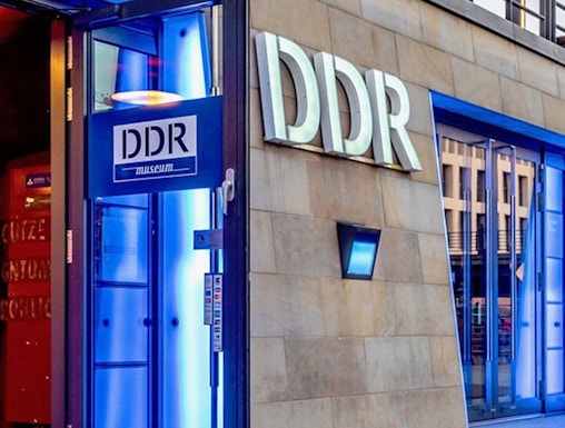DDR Museum entrance in Berlin with illuminated blue doorway.