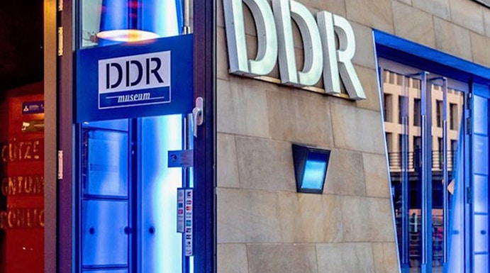 DDR Museum entrance in Berlin with illuminated blue doorway.