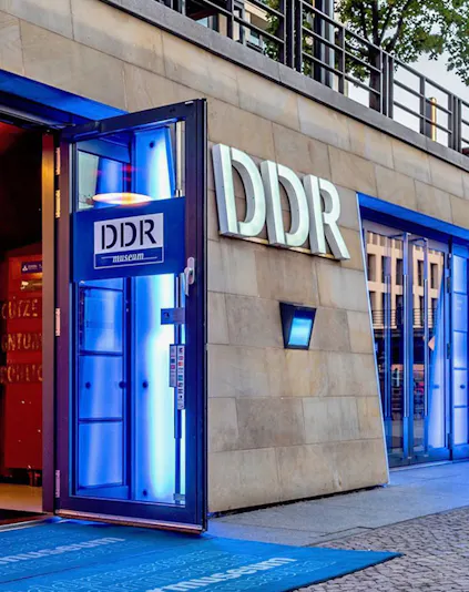 DDR Museum entrance in Berlin with illuminated blue doorway.