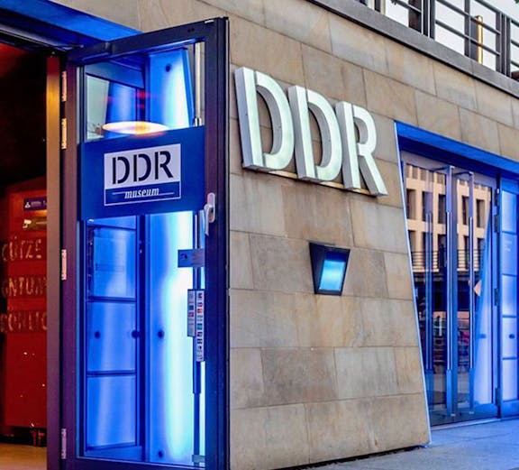 DDR Museum entrance in Berlin with illuminated blue doorway.