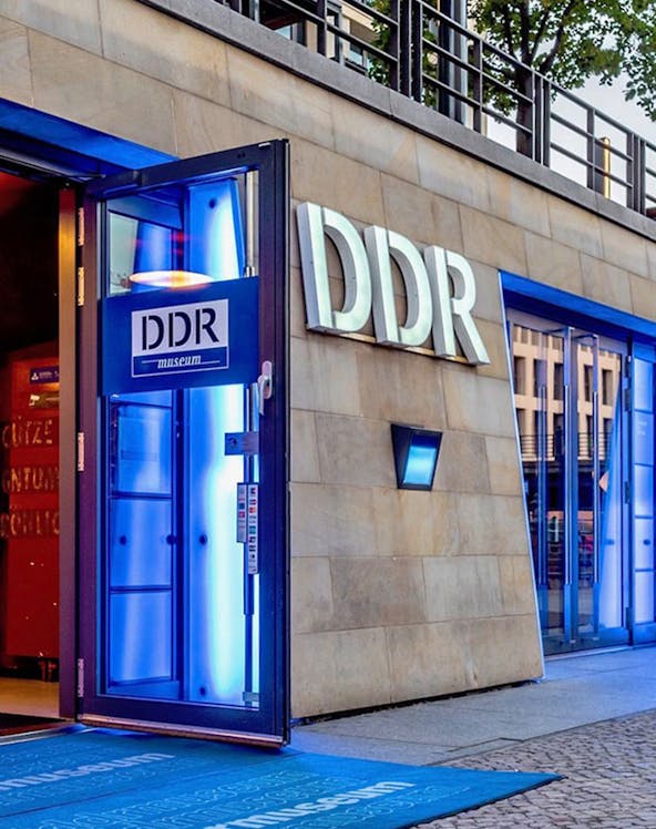 DDR Museum entrance in Berlin with illuminated blue doorway.