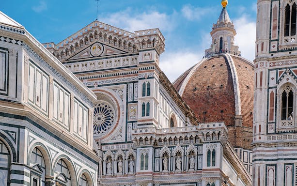 Florence Cathedral exterior with detailed frescoes and iconic dome.