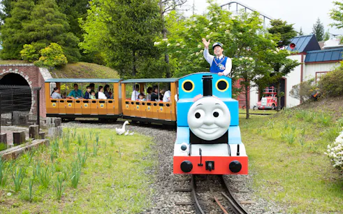 Miniature train ride at Fuji Q Highland with passengers enjoying the scenic route.