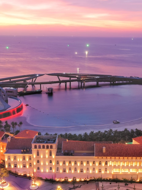 Nighttime view of Sun World Hon Thom with illuminated buildings and a scenic coastline.