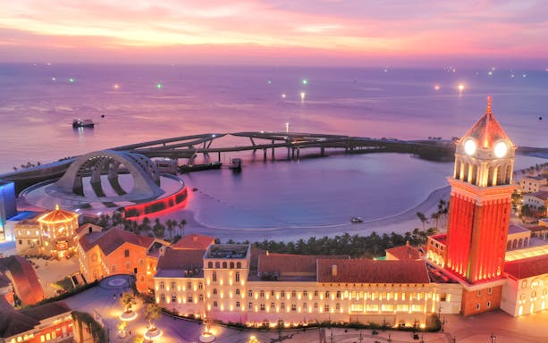 Nighttime view of Sun World Hon Thom with illuminated buildings and a scenic coastline.