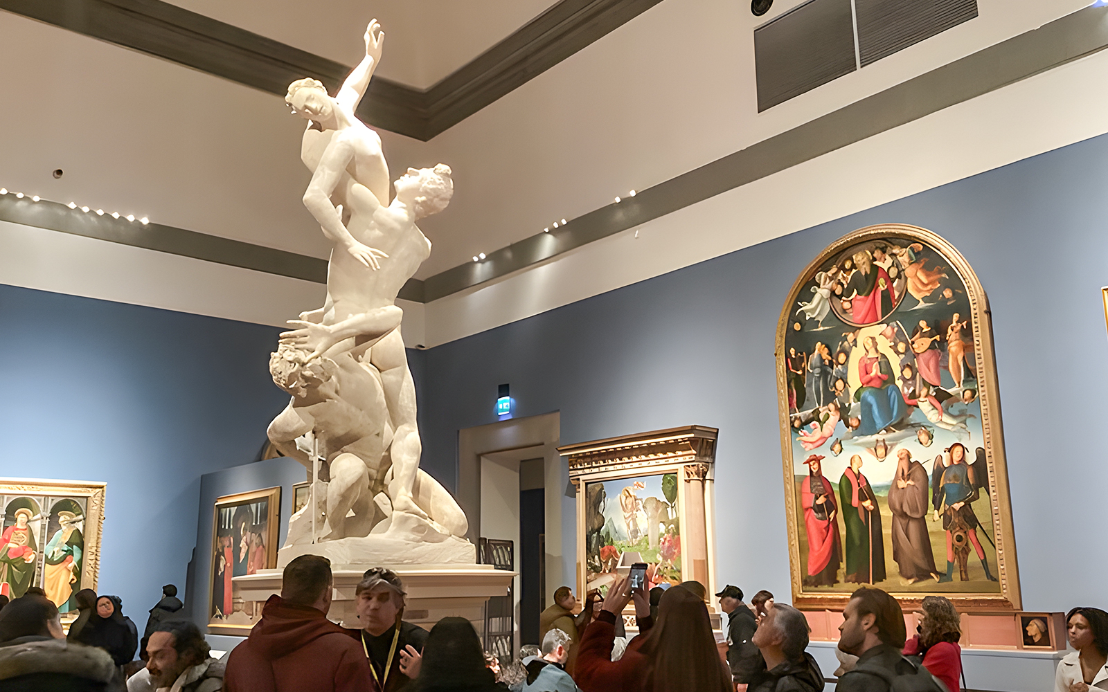 David statue in Accademia Gallery, Florence, with visitors viewing art on timed entry tickets.