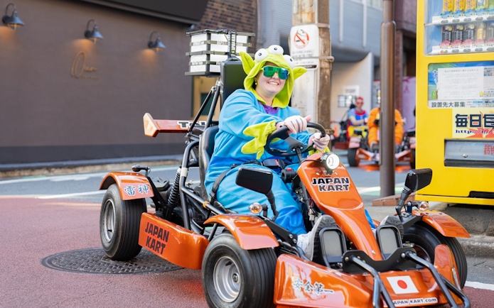 Woman in costume driving a go-kart on Shibuya Shinjuku Tour, Tokyo.