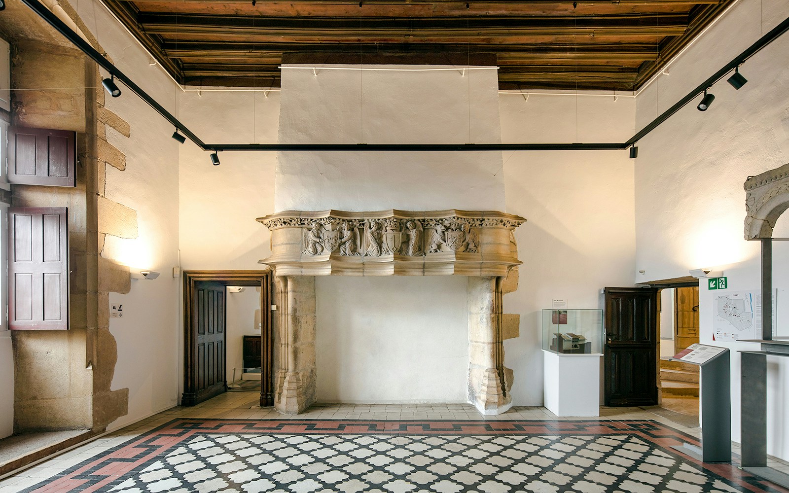 Medieval relief fragment in Abbaye de Cluny, Lyon, France, displayed in a historic room.