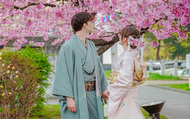 Couple in Yukata under cherry blossoms in Japan.