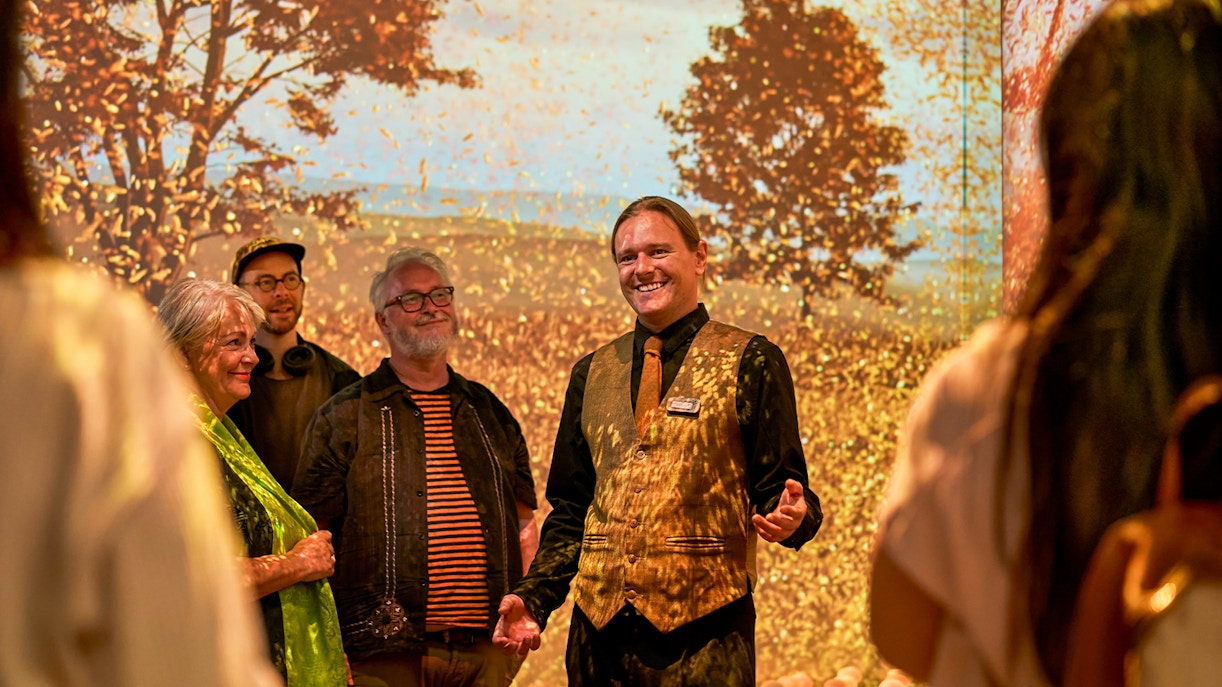 Guide leading visitors on a sensory journey through Scotland with autumn backdrop.