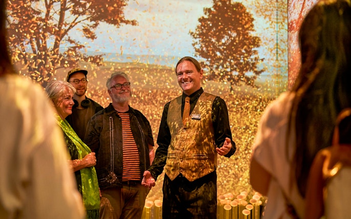 Guide leading visitors on a sensory journey through Scotland with autumn backdrop.